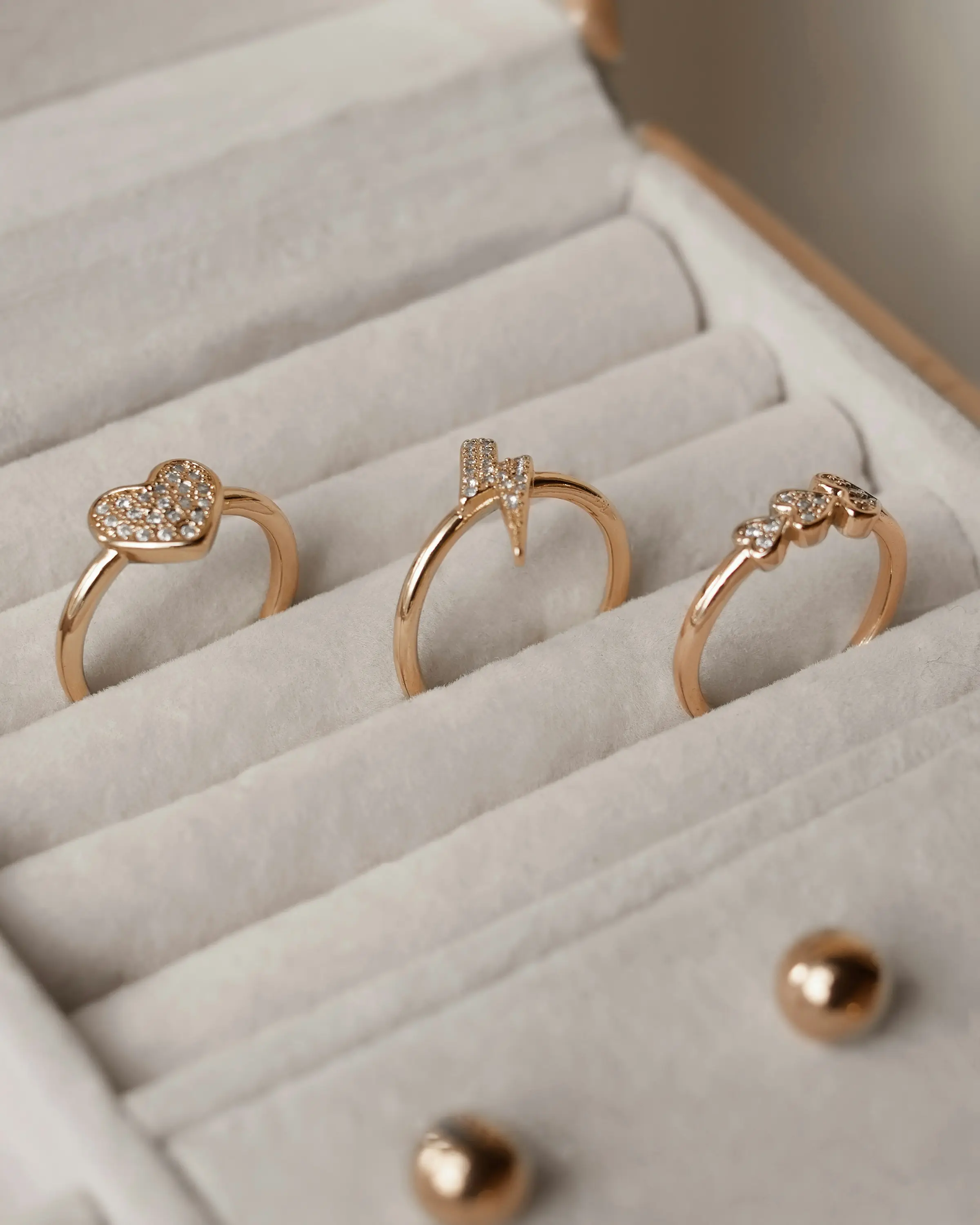 Tre anelli d'oro rosa nell'astuccio della vetrina