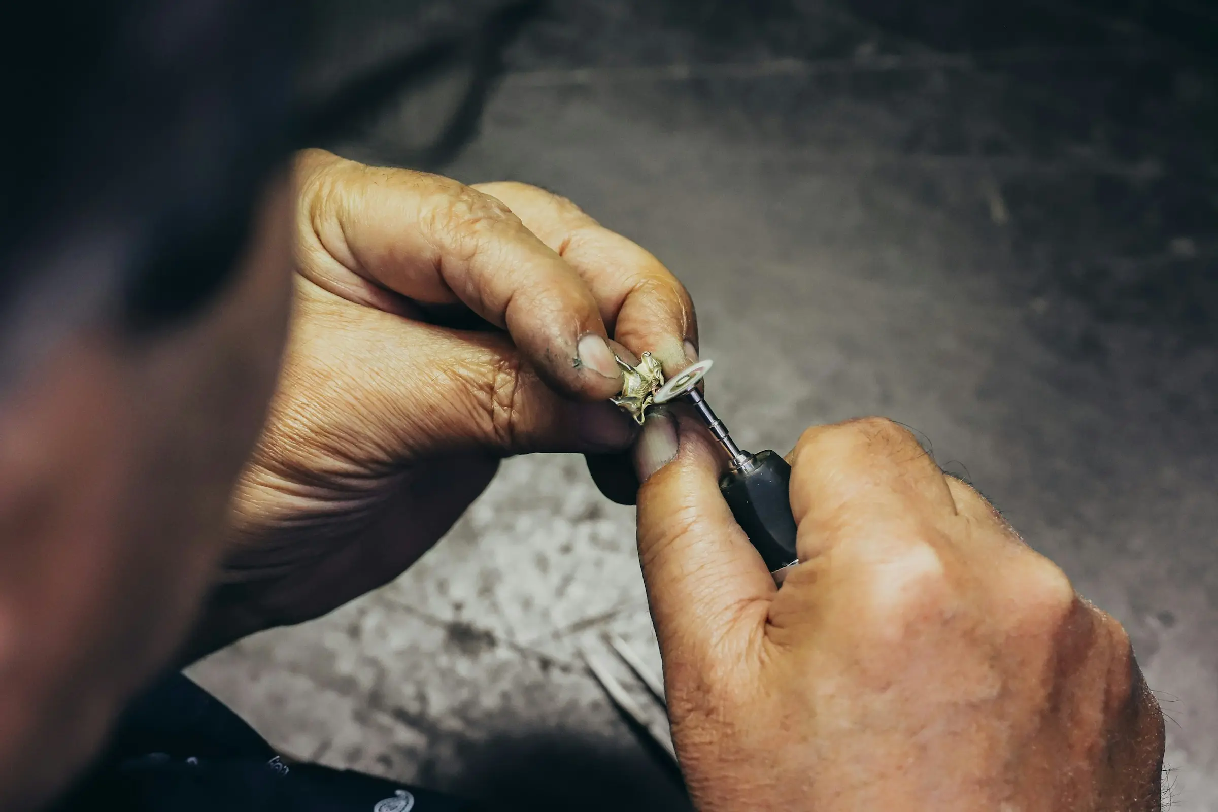 Le mani dell'orafo fissano una pietra in un anello con il bulino